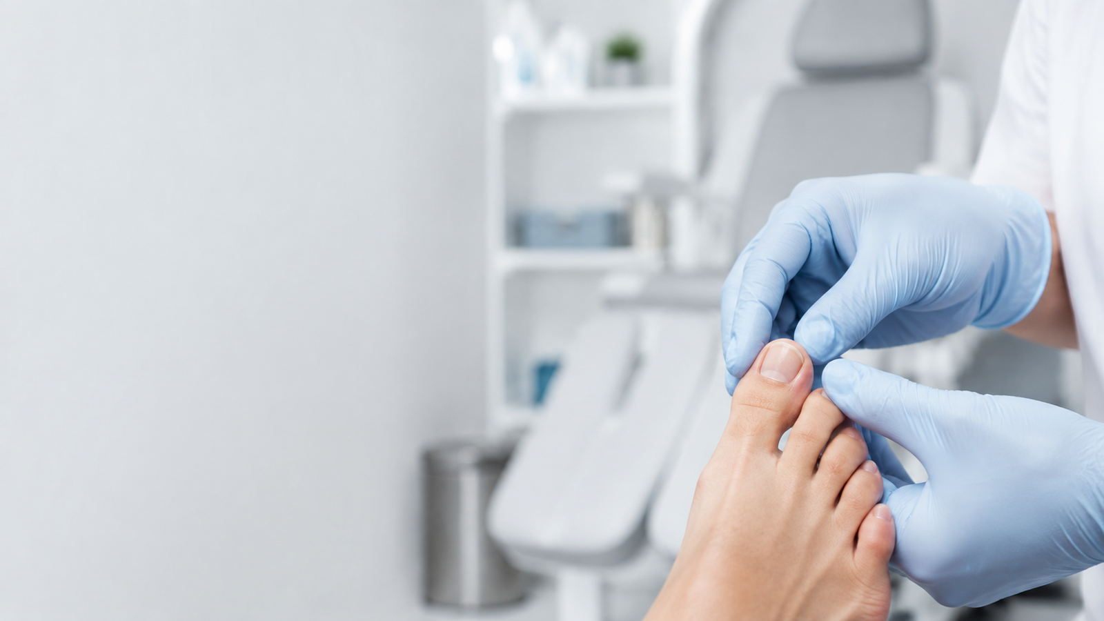 A podiatrist examines a patient's toenail in a clinic — care for a toenail separating from the nail bed